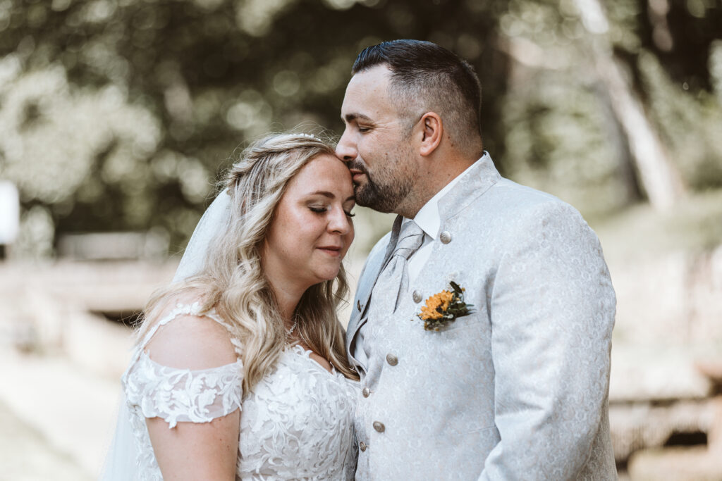 Hochzeit Heidsmühle - Bräutigam küsst seine Braut auf die Stirn